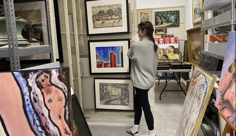 Museum and Curatorial Studies student working in the Hand Art Center's art vault.